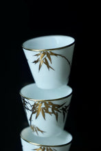 Load image into Gallery viewer, Tongxin She Teahouse Selection | Creamy White Gilded Bamboo Teacups Snow-white porcelain adorned with bamboo painted in gilded pigment.
A gilded rim encircles the cup, freezing tranquil time upon the vessel.
